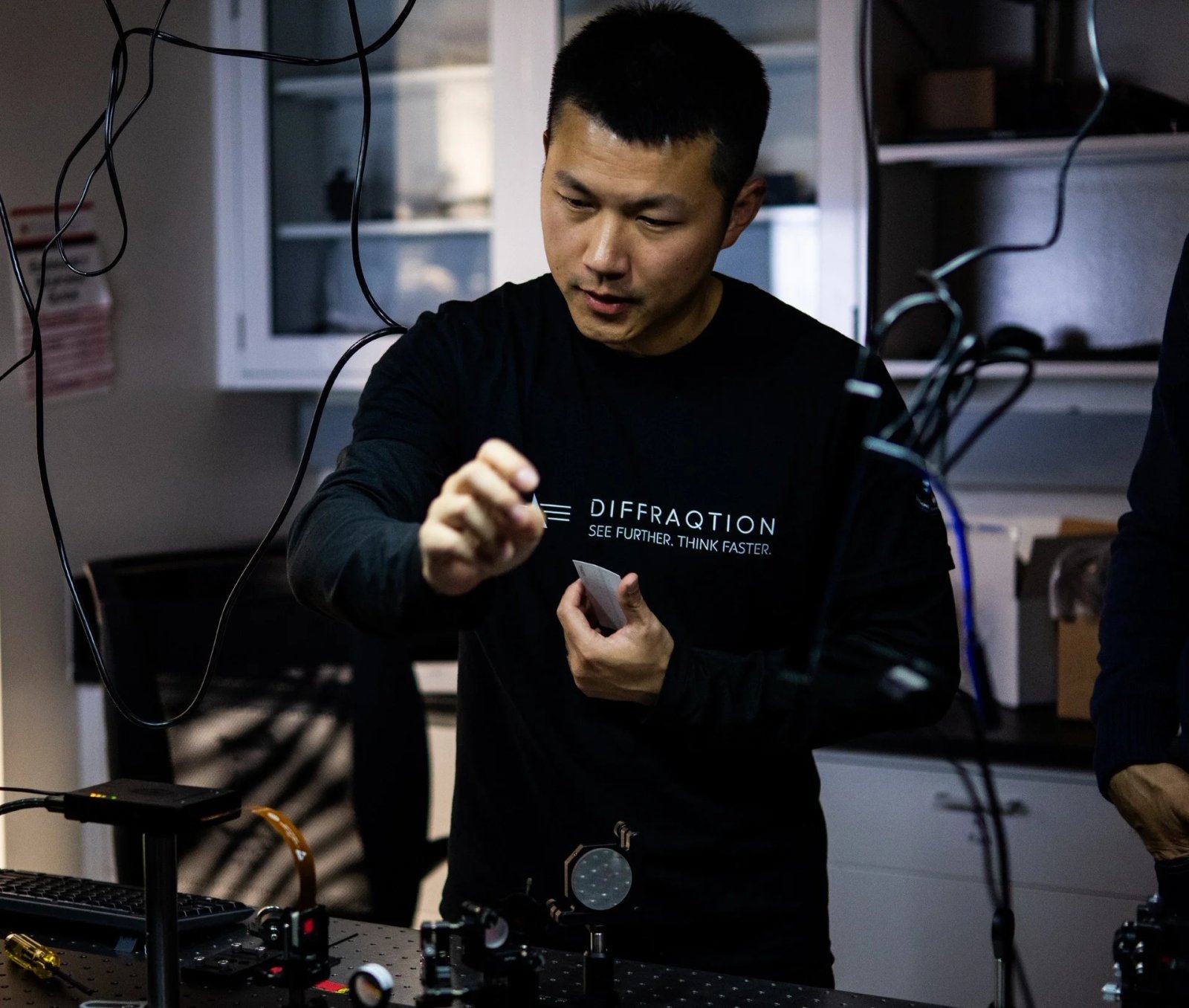 Man conducting scientific experiment with wires and equipment in a laboratory.